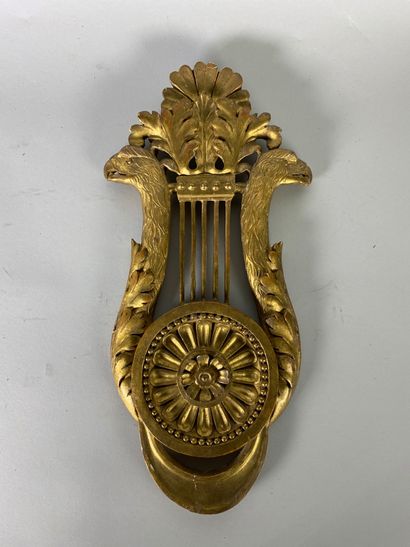 null Elément en bois doré sculpté d'une lyre à montants terminés par des têtes d'aigle.

XIXe...