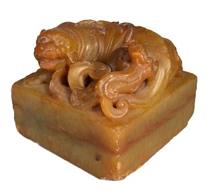  Honey-colored soapstone cachet, square in shape, the upper part carved in the round...