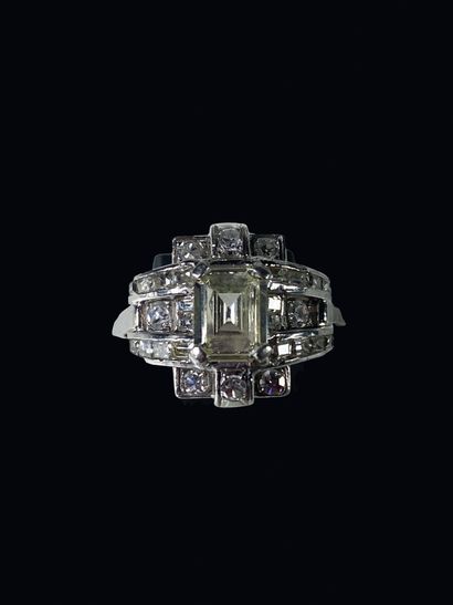 null Platinum ring set with an emerald-cut diamond surrounded by two lines of baguette-cut...