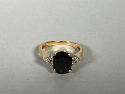 null Bague en or jaune 18K (750°/°°) serti d'une pierre bleue épaulée de six petits...