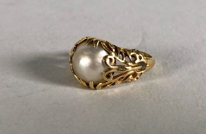 null Bague en jaune 18K (750°/°°), l'anneau ajouré d'arabesques, le chaton serti...