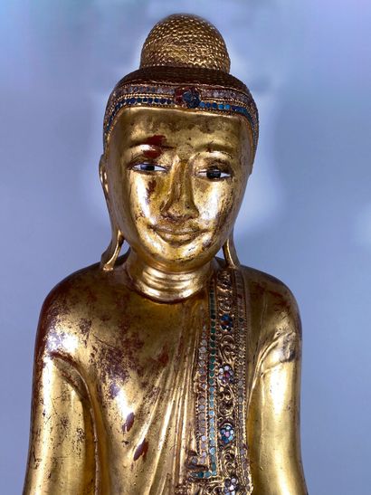 null Large carved and gilded wood Buddha, enriched with glass tesserae, depicted...