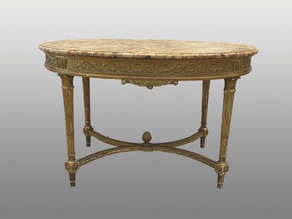 null Moulded, carved and gilded wood oval middle table resting on tapered and fluted...