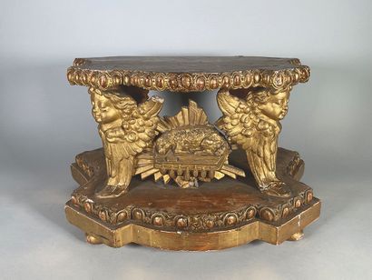 null Gilded wood base, the four legs carved with busts of cherubs, surrounding the...