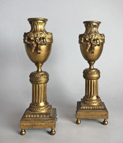 null Paire de bougeoirs-cassolettes en bronze doré et ciselé en forme d'urne reposant...