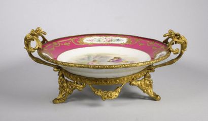 SÈVRES 
Assiette en porcelaine à décor polychrome en réserve d'une scène galante...