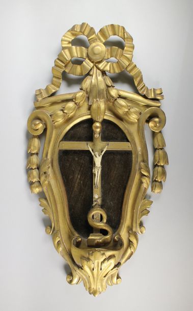 null Crucifix en ivoire dans un cadre en bois sclupté doré à décor de rubans et d'éléments...