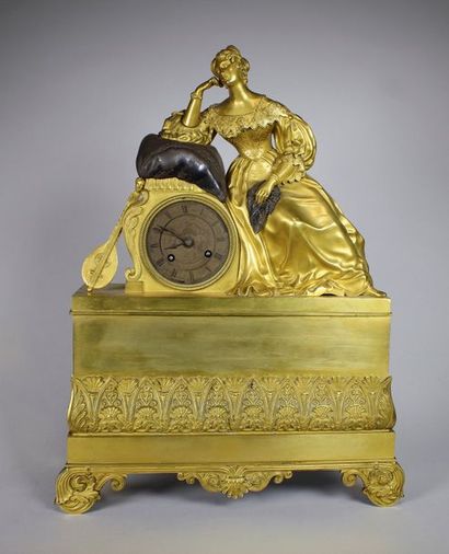 null Pendule en bronze patiné et doré ornée d'une femme accoudée sur un coussin,...