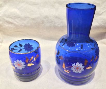 null Verre d’eau et sa carafe assortie en verre bleu à décors de fleurs

Vers 19...