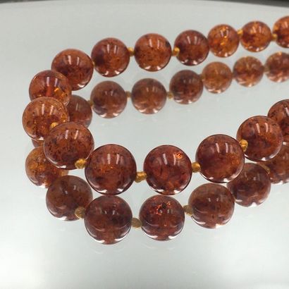 null NECKLACE made up of a string of round amber beads, falling. Metal clasp. 

Diam....