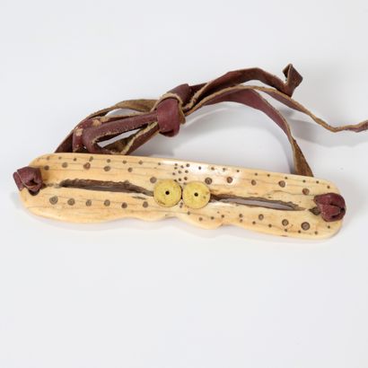 null Bone or marine ivory eyeglasses with incised round motifs, joined by a ligature...