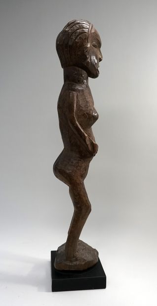 null Statue féminine présentée debout, les jambes écartées et légèrement fléchies....