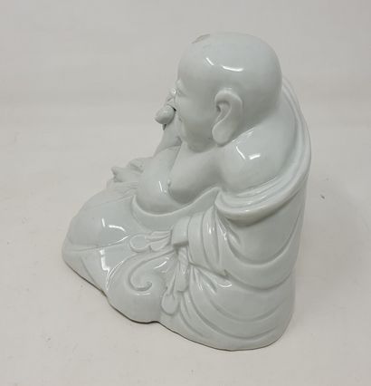 null Chinese white" porcelain statue of Budai smiling, sitting against the bag of...
