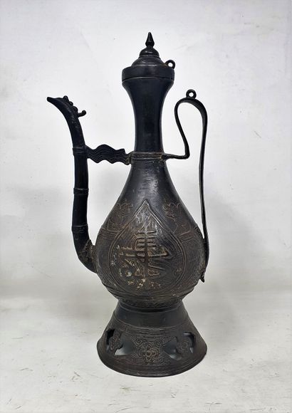 null A bronze covered pear-shaped jug decorated with medallions of the characters...