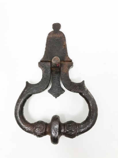 null Doorknocker in wrought iron and carved with two masks. The bulbs of the twisted...