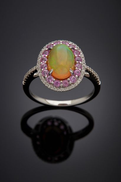 null White gold (750‰) oval ring adorned with a cabochon opal, surrounded and shouldered...