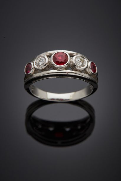 null A white gold (750‰) openwork ring set with three round rubies and two brilliant-cut...