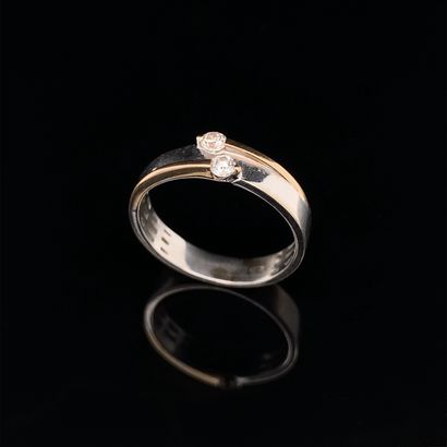 null White gold and yellow gold (750‰) ring set with two brilliant-cut diamonds....