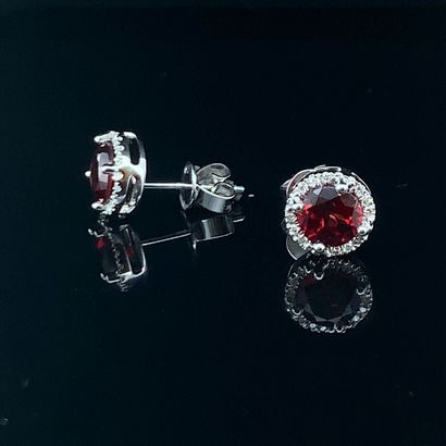 null Pair of EARRINGS in white gold (750‰) set with a round garnet, surrounded by...