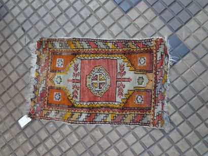 null Petit tapis Caucase fond rouge, à décor de médaillons losangiques bordure de...