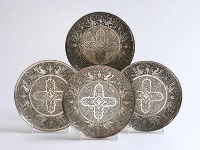 null Quatre ASSIETTES en métal argenté amati, ciselé et sculpté, à décor de chimères,...