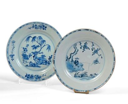 null Deux assiettes en porcelaine à décor en camaïeu bleu, l'une d'un chinois pêchant...