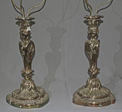 null Paire d'importants flambeaux en bronze argenté à décor Rocaille, montés en lampes.

Style...