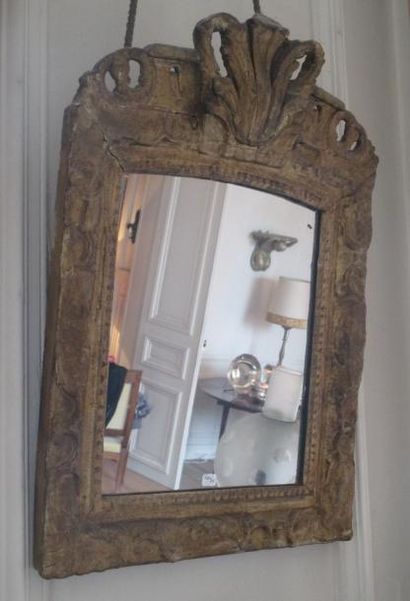 null Glace en bois doré à motif berain et agraphe 
époque Régence 
64x40 cm (miroir...