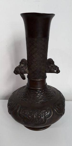  Vase à long col en métal à décor d'écailles et de tête de taotié, prise en tête...