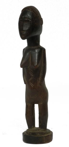 null Ancienne statuette féminine Baoulé (Côte d'Ivoire), le visage poli par de nombreuses...