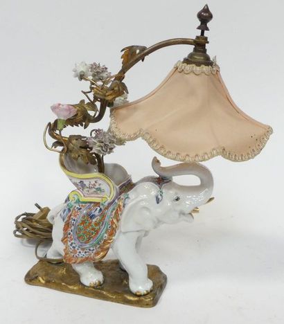 null Petite LAMPE figurant un éléphant en porcelaine à décor polychrome, le bras...