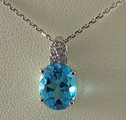 null White gold pendant and chain set with a faceted oval topaz enhanced with diamonds....