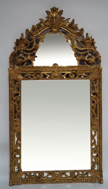 A wood and gilded stucco mirror decorated...