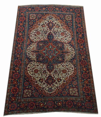 null TAPIS KESHAN à rosace centrale florale rouge sur fond bleu. 203 x 137 cm.