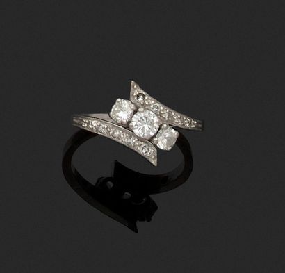 null White gold cross ring, the setting set with roses holding three claw-set diamonds....