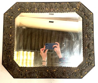 null Miroir octogonal en bois recouvert de tôle laquée noir et doré repoussé, à décor...
