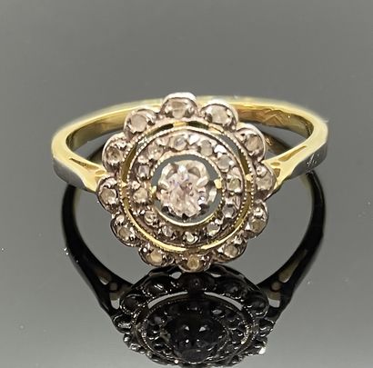 null Fine BAGUE deux ors, le chaton rond festonné serti de roses et diamant central....