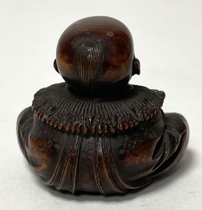 null JAPON, XIXe. NETSUKE en bois, enfant assis souriant, une large collerette autour...