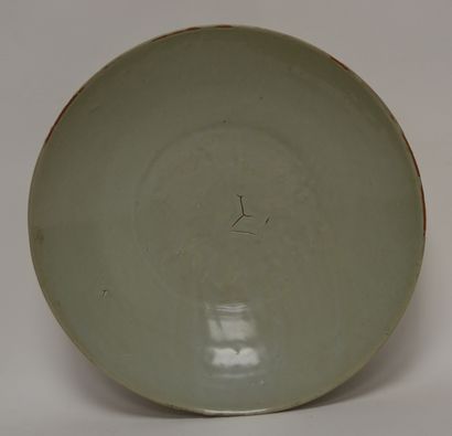 null CHINA, 18th-19th century. Large round hollow dish in celadon glazed stoneware...