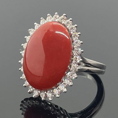 null RING in white gold 750 mils set with a coral cabochon in a diamond setting....