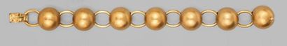 null G. FACCHINELLI. BRACELET articulé en or jaune formé de sept boules d'or brossé...