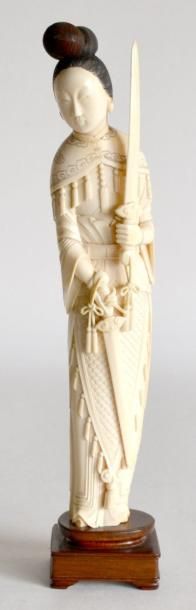 null SUJET en ivoire, sculpté, femme debout tenant deux glaives. Chine vers 1930....