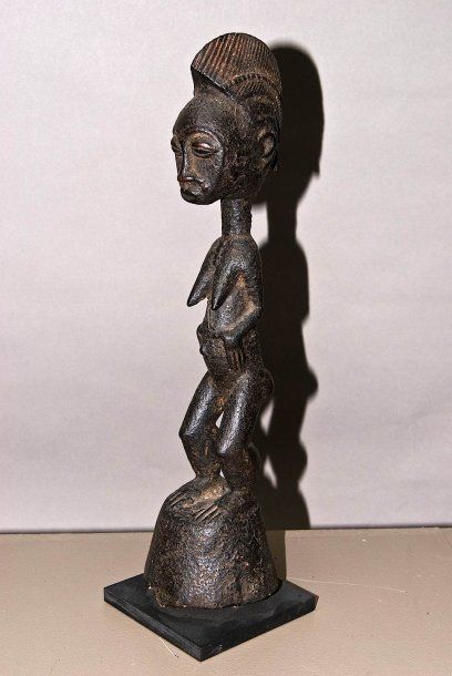 null Baoulé R.C.I Elégante statuette féminine debout sur une large base conique....
