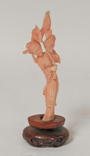 null SUJET en corail peau de pêche figurant une femme tenant un rameau. H. 13 cm....