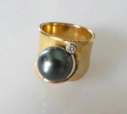 null Belle BAGUE moderniste en or jaune, ornée d'une importante perle noire et rehaussée...