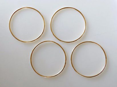 null QUATRE BRACELETS rigides en or jaune ciselés d'un motif géométrique répété....