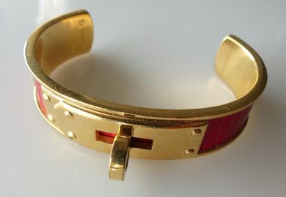 null HERMES. BRACELET rigide en métal doré et cuir rouge façon serpent, pouvant former...