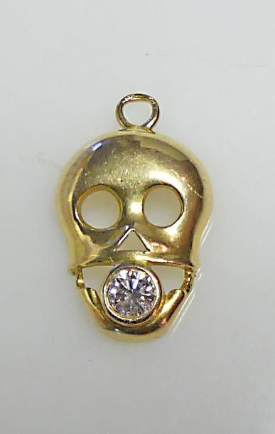 null PENDENTIF en or jaune en forme de tête de mort, serti d'un diamant taille brillant....