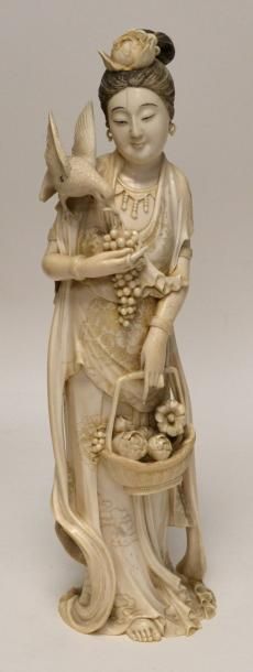 null Grand OKIMONO en ivoire sculpté, Ganyin, portant sur son épaule un oiseau picorant...