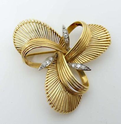 null BROCHE en fils d'or jaune, trilobée, rehaussée de trois motifs en platine sertis...